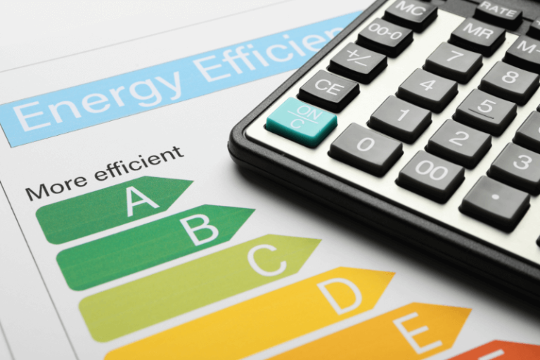 Etiqueta de eficiencia energética con letras A a G junto a una calculadora, símbolo del cálculo de reformas necesarias para cumplir el certificado energético 2030 en viviendas
